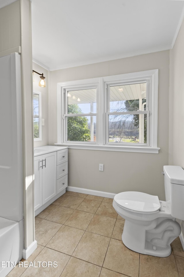 bathroom featuring tile patterned flooring, vanity, a healthy amount of sunlight, and toilet