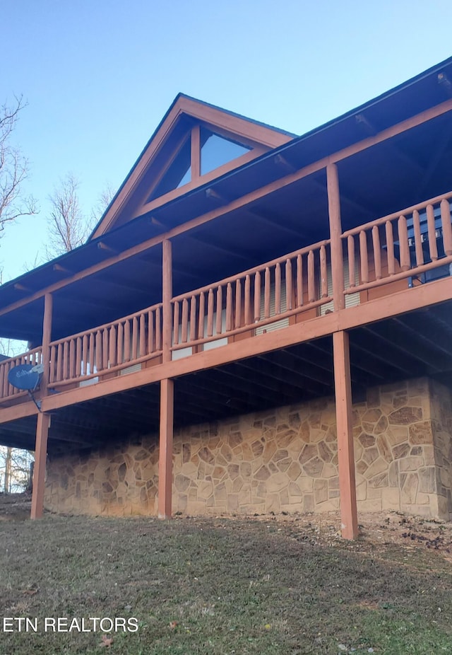 view of property exterior with a lawn and a wooden deck