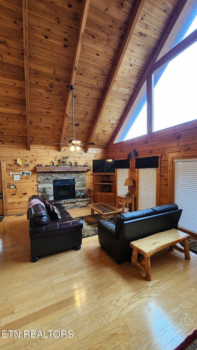 living room featuring wooden ceiling, beamed ceiling, high vaulted ceiling, wooden walls, and light wood-type flooring