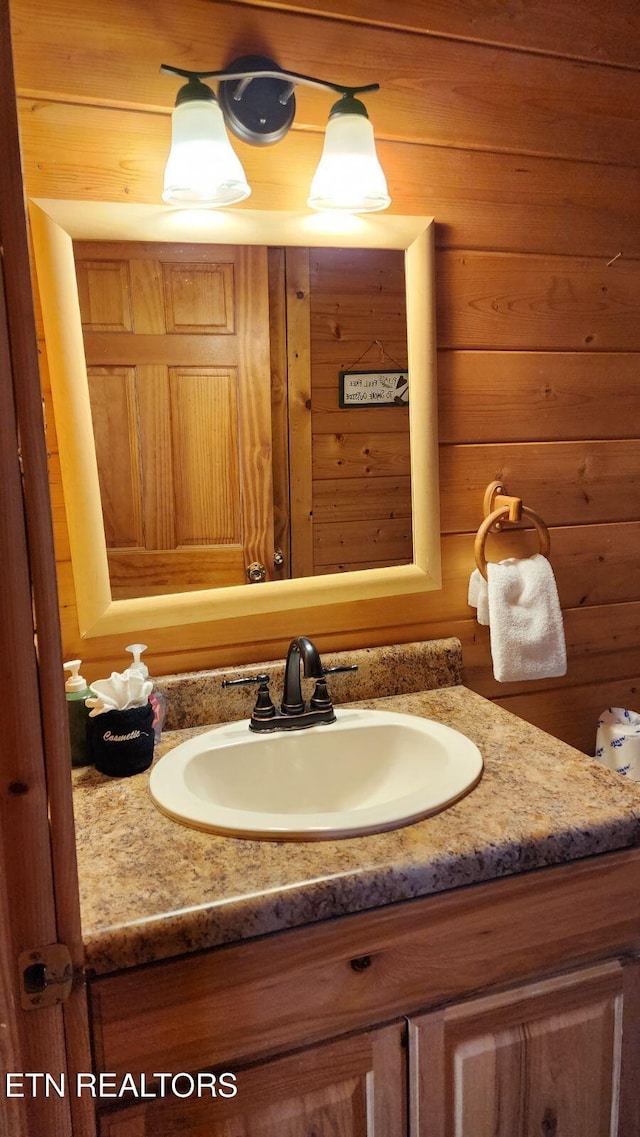 bathroom featuring wood walls and vanity