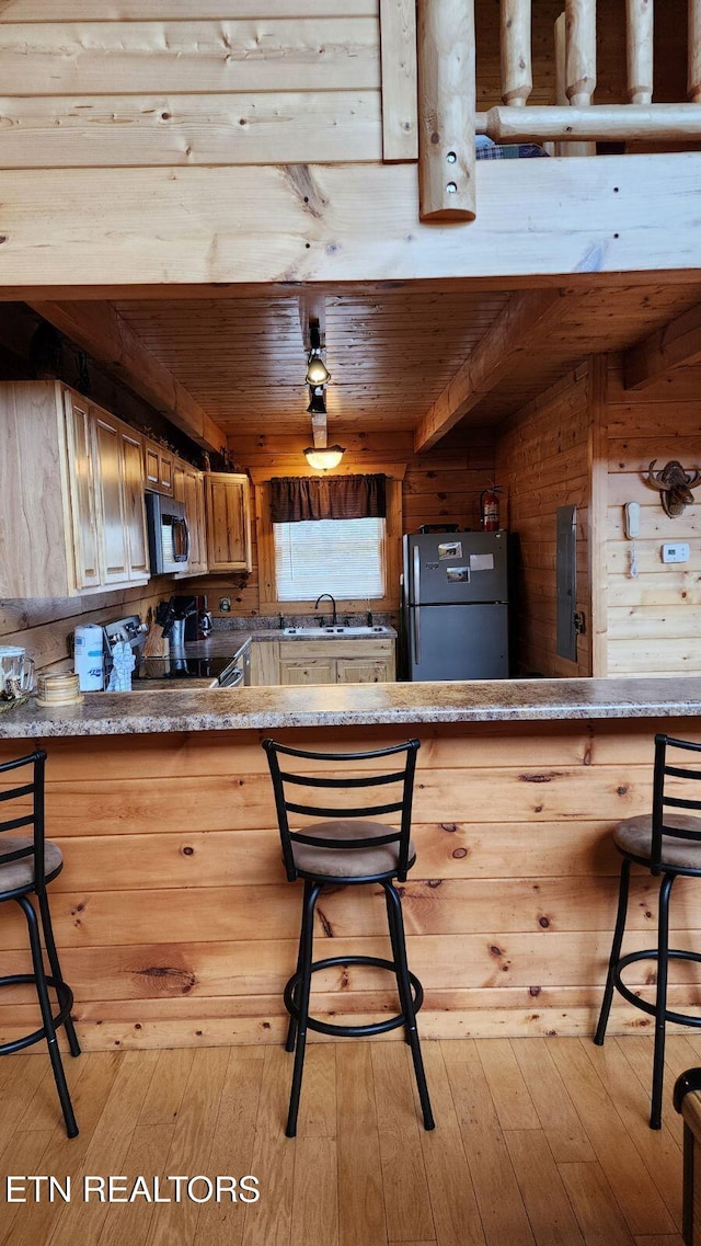 kitchen featuring sink, wooden ceiling, light wood-type flooring, and appliances with stainless steel finishes