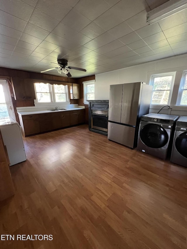 kitchen featuring sink, washer and dryer, ceiling fan, dark hardwood / wood-style flooring, and stainless steel refrigerator