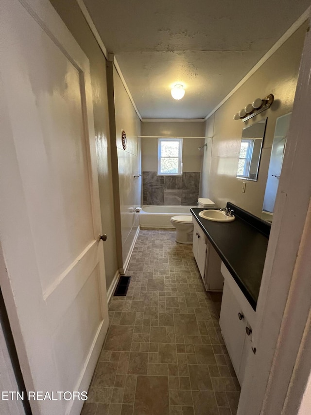 full bathroom with vanity, toilet, ornamental molding, and tiled shower / bath