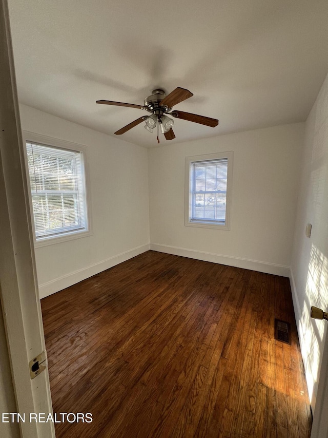 spare room featuring ceiling fan and dark wood-type flooring