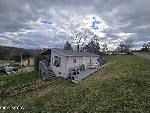 rear view of property with a lawn and a wooden deck