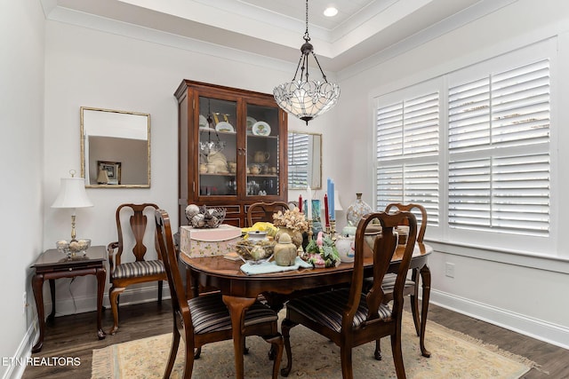 dining space with ornamental molding, dark wood-type flooring, a wealth of natural light, and an inviting chandelier