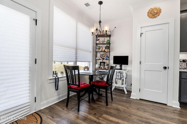 dining room with ornamental molding, dark wood-type flooring, and a notable chandelier