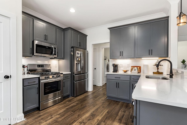 kitchen featuring decorative backsplash, appliances with stainless steel finishes, gray cabinetry, sink, and decorative light fixtures