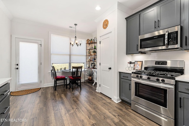 kitchen featuring appliances with stainless steel finishes, an inviting chandelier, pendant lighting, and gray cabinetry