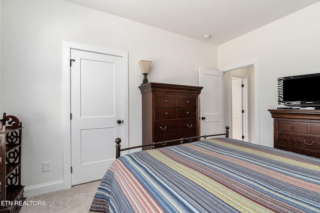 bedroom with a closet and light colored carpet