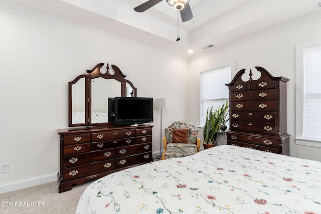 bedroom with ceiling fan, crown molding, light colored carpet, a tray ceiling, and multiple windows