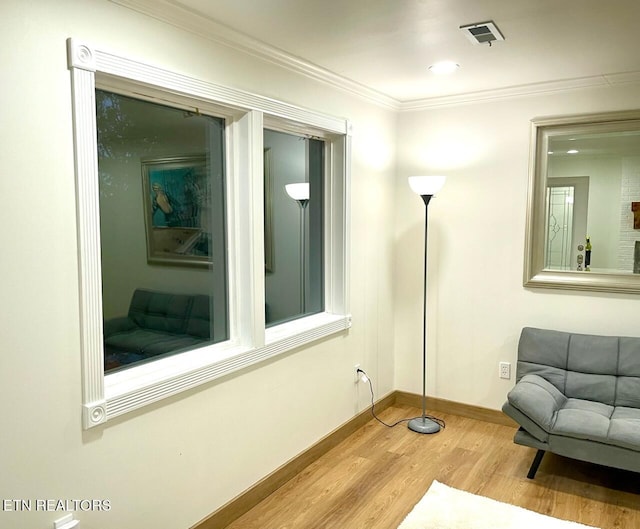 living area featuring hardwood / wood-style flooring and ornamental molding