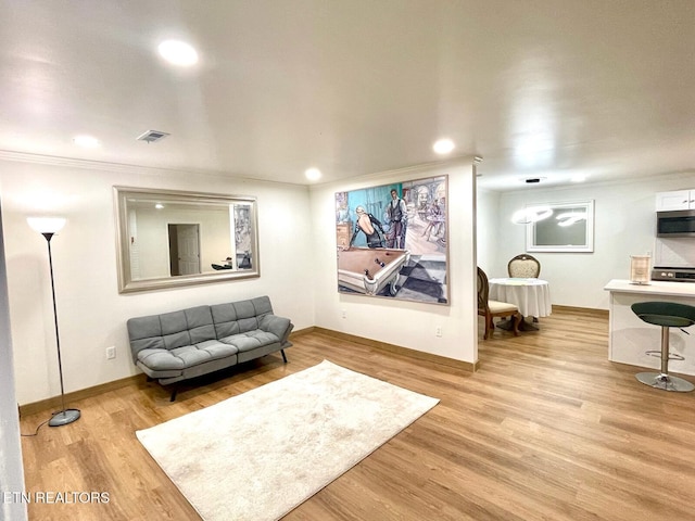 sitting room featuring light hardwood / wood-style floors and crown molding