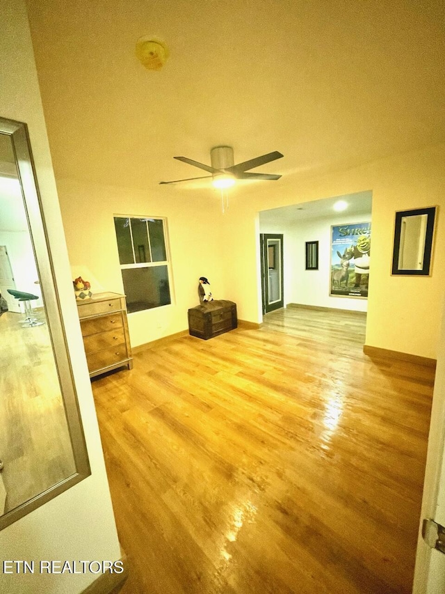 unfurnished living room with built in shelves, ceiling fan, and hardwood / wood-style flooring