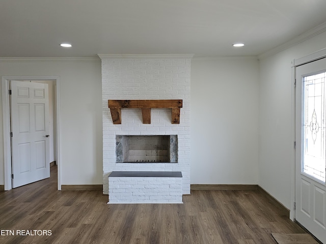 unfurnished living room featuring a fireplace, dark hardwood / wood-style flooring, a healthy amount of sunlight, and ornamental molding