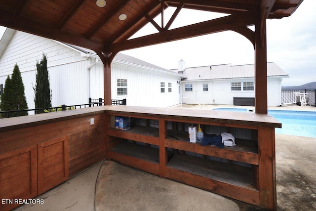 view of patio with a gazebo and a swimming pool with hot tub