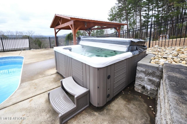 view of patio / terrace featuring a gazebo and a swimming pool with hot tub