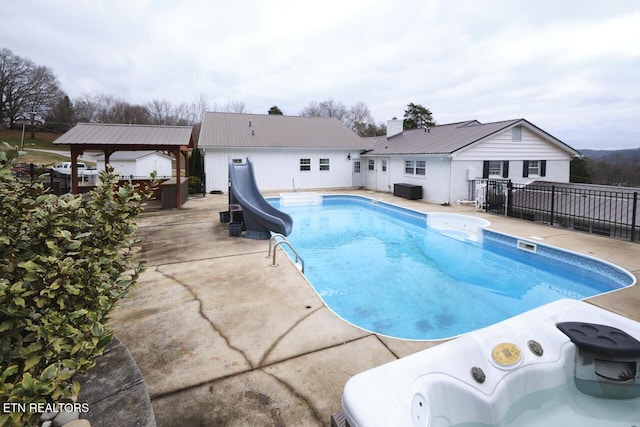 view of swimming pool with a gazebo, a water slide, and a patio