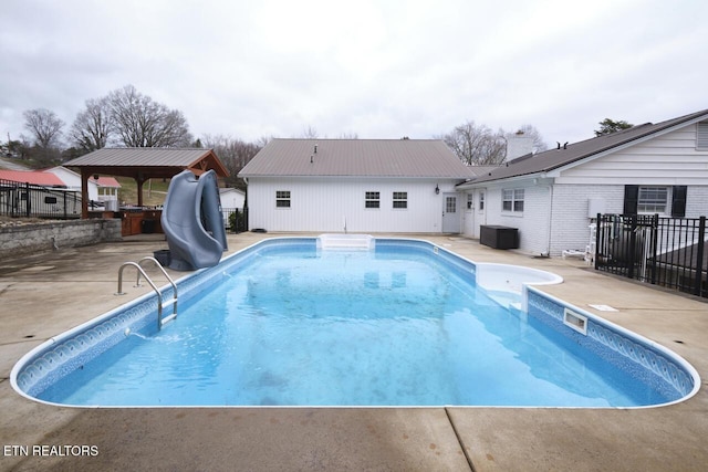 view of swimming pool featuring a gazebo, central air condition unit, a water slide, and a patio