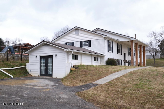 view of front facade with a front lawn and french doors