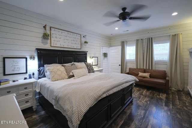 bedroom with wood walls, dark hardwood / wood-style floors, and ceiling fan