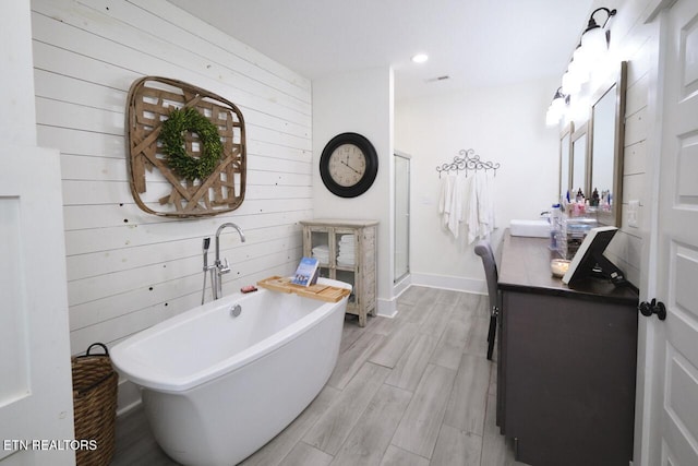 bathroom with vanity, wood walls, and shower with separate bathtub