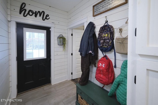 mudroom featuring wood walls