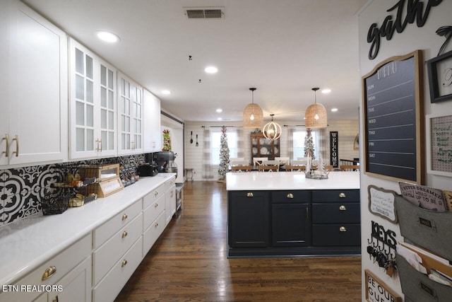 kitchen featuring dark wood-type flooring, white cabinets, and pendant lighting