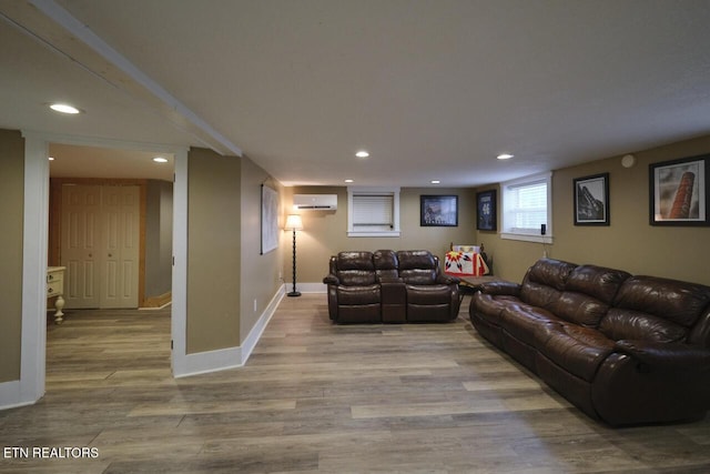 living room with light hardwood / wood-style floors and an AC wall unit