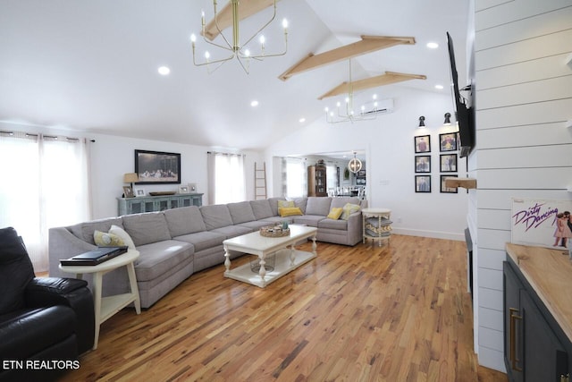 living room featuring a notable chandelier, a wall mounted air conditioner, light hardwood / wood-style floors, and high vaulted ceiling