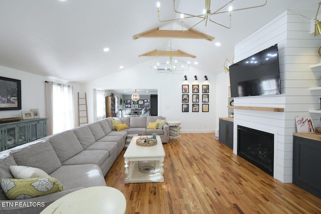 living room featuring high vaulted ceiling, a fireplace, beamed ceiling, a chandelier, and light wood-type flooring