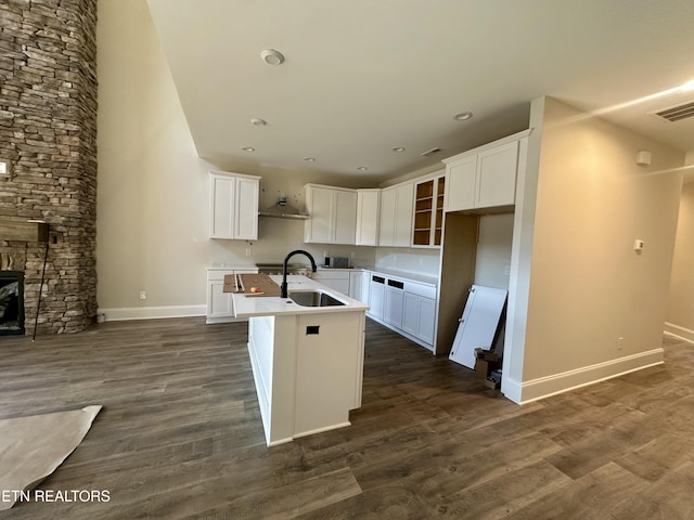 kitchen with sink, white cabinets, a kitchen island with sink, and dark hardwood / wood-style floors