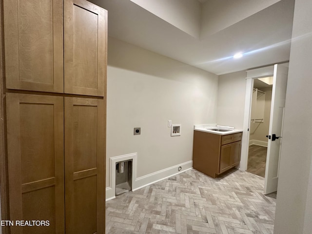 clothes washing area featuring sink, hookup for a washing machine, hookup for an electric dryer, and cabinets