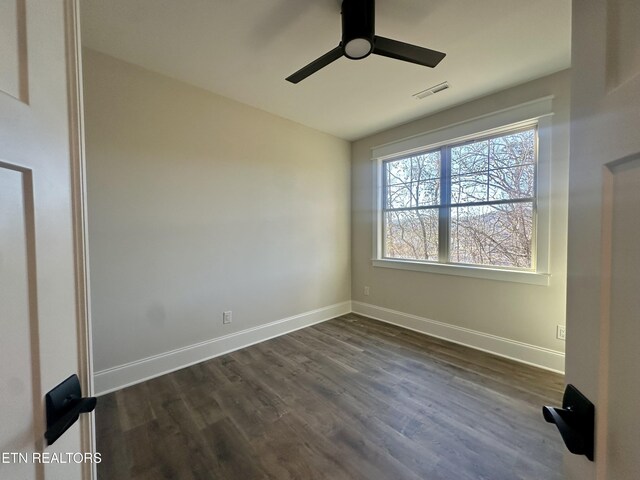 empty room featuring ceiling fan and dark hardwood / wood-style flooring