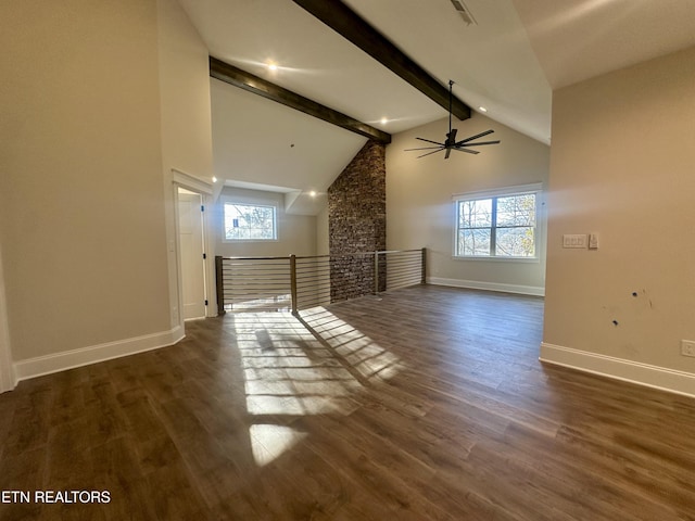 additional living space with beamed ceiling, a healthy amount of sunlight, and dark hardwood / wood-style floors