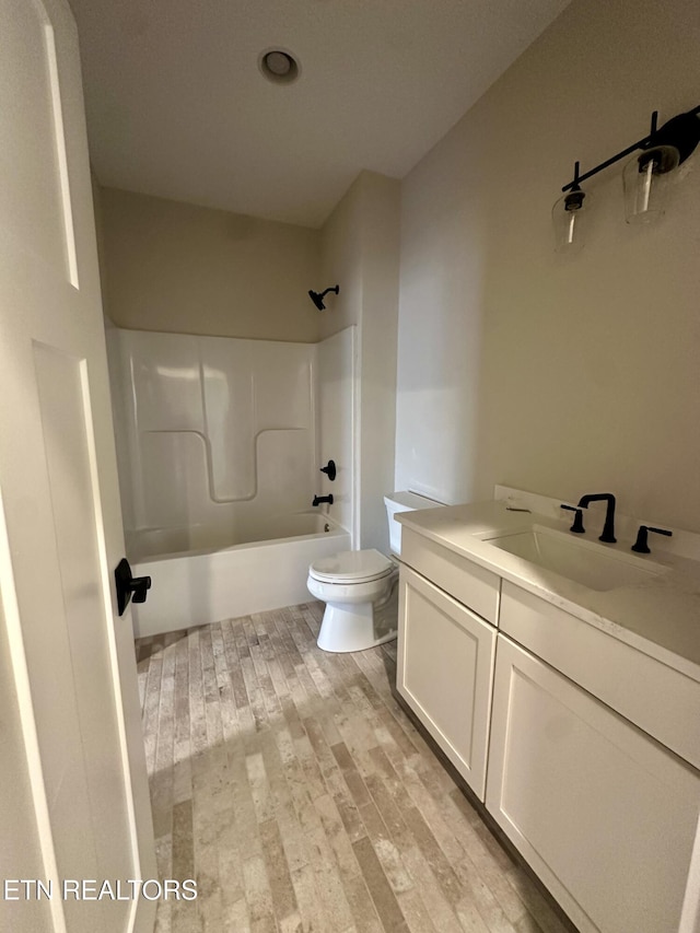 full bathroom featuring hardwood / wood-style flooring, toilet, vanity, and bathing tub / shower combination