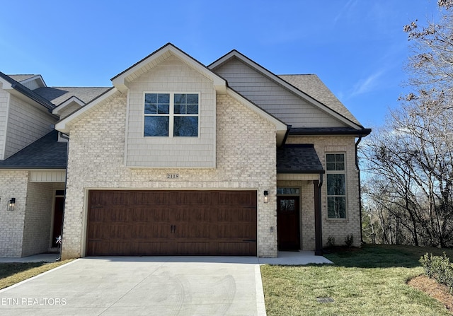 view of front of house with brick siding, driveway, a shingled roof, and a front yard