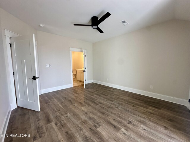 unfurnished bedroom featuring visible vents, ensuite bathroom, a ceiling fan, dark wood-style floors, and baseboards