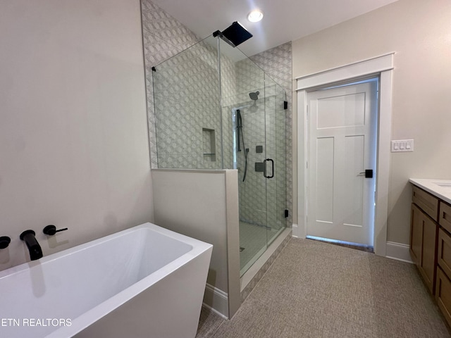 full bath featuring vanity, a freestanding tub, baseboards, and a stall shower