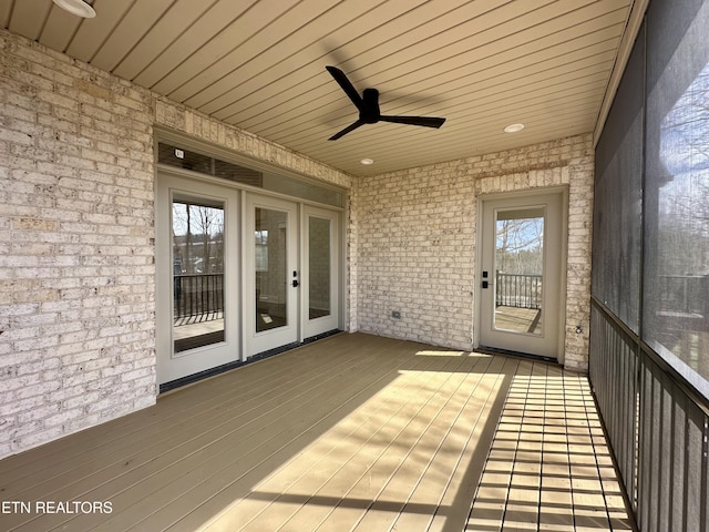 unfurnished sunroom featuring plenty of natural light, wooden ceiling, and ceiling fan