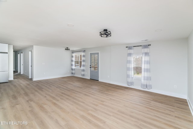 unfurnished living room featuring light hardwood / wood-style floors and a wealth of natural light