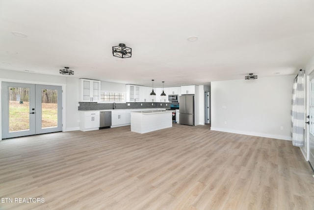 unfurnished living room featuring light hardwood / wood-style floors and french doors