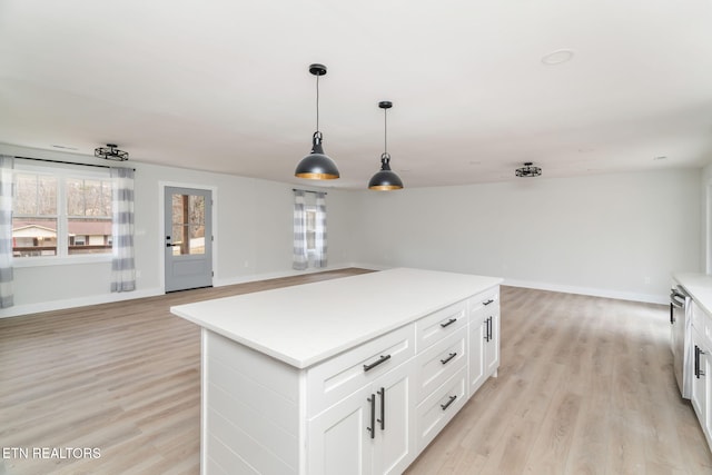 kitchen with a center island, white cabinets, pendant lighting, and light hardwood / wood-style floors