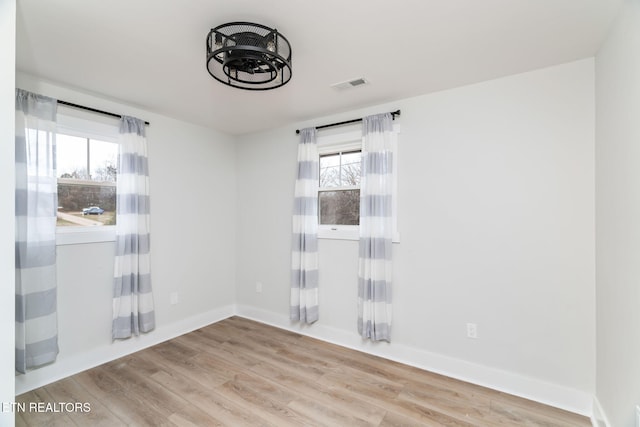 empty room featuring plenty of natural light and light hardwood / wood-style flooring