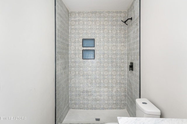 bathroom featuring toilet and tiled shower