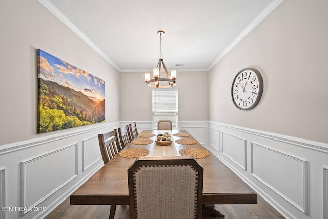 dining area with dark wood-type flooring, crown molding, and a chandelier