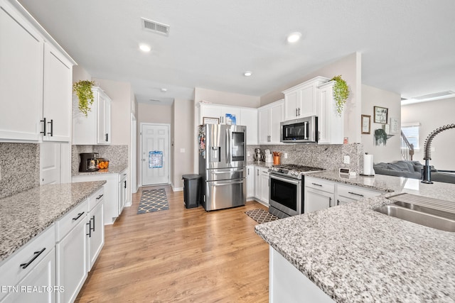 kitchen featuring white cabinets, decorative backsplash, sink, and stainless steel appliances