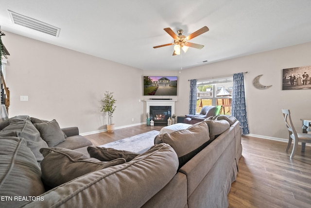 living room featuring wood-type flooring and ceiling fan