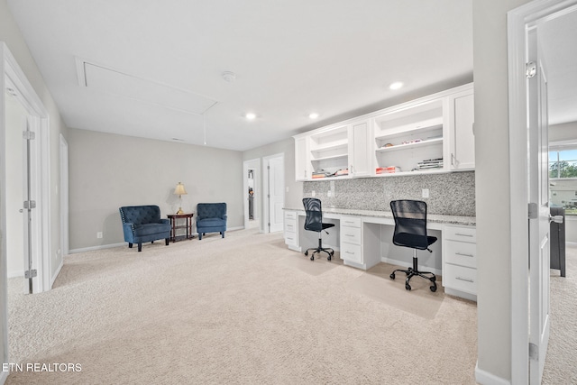 office space featuring built in desk and light carpet