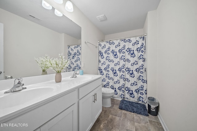 bathroom with vanity, toilet, and walk in shower